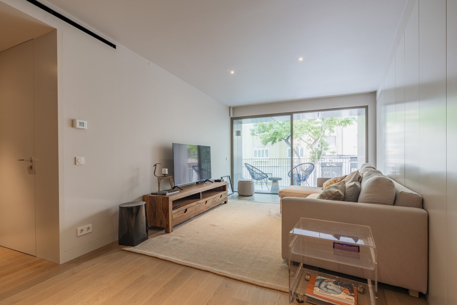 Sala com zona de televisão e acesso à varanda